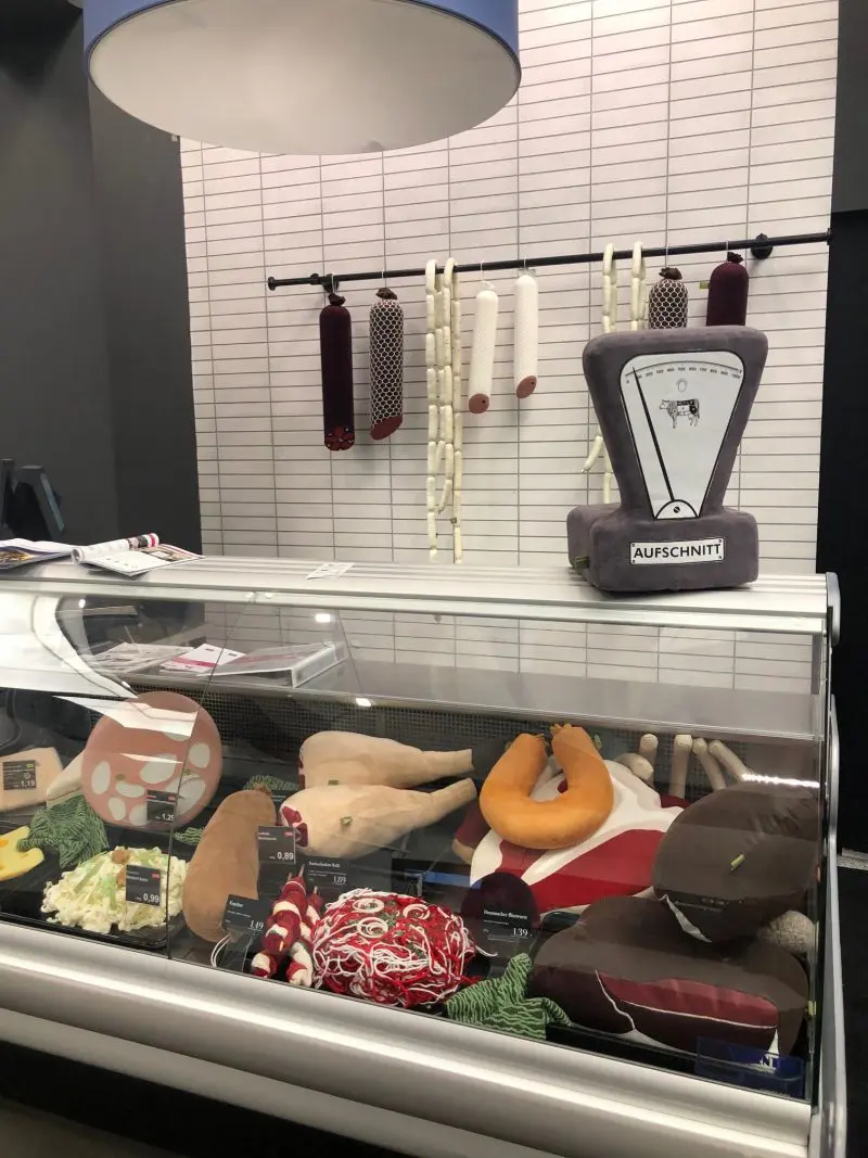 Die Nackenrolle von Aufschnitt Berlin ist ein gemütliches Nackenkissen in textilem Wurstdesign. Das Wurstkissen erhält seine Fleischoptik durch seine aufgeschnittene Seite.