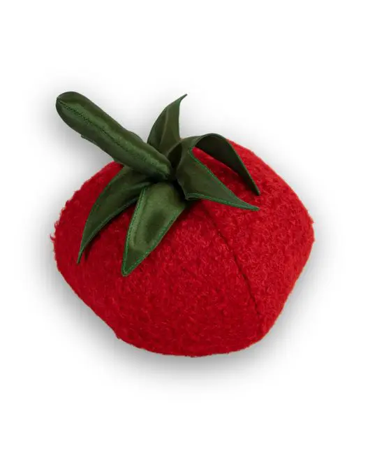 Tomatenkissen aus rotem Plüsch schräg von oben, mit Stiel und abstehenden Blättern aus dunkelgrünem Seidensatin